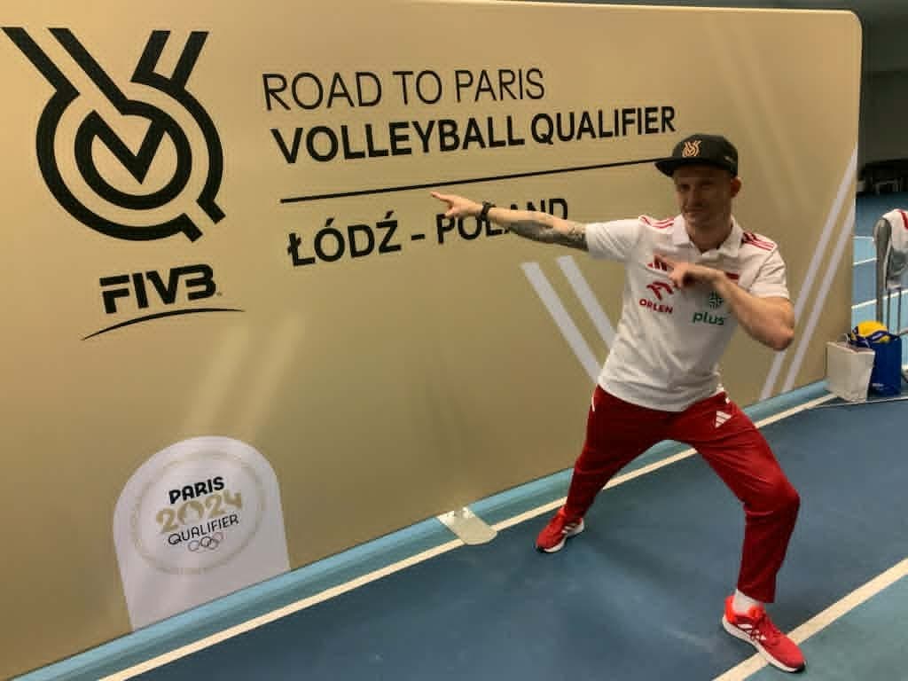 Fizjoterapeuta na tle tablicy Road to Paris Volleyball Qualifiers Łódź